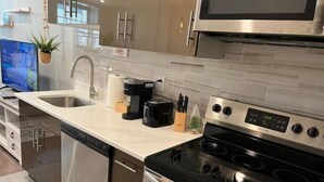 A modern kitchen with stainless steel appliances, a built-in oven, and a microwave. - 308 Cozy and warm  King Bed APT in center city
 (Philadelphia)