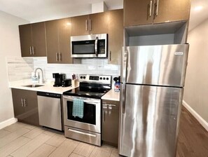 A modern kitchen with stainless steel appliances, including a microwave, oven, and refrigerator.