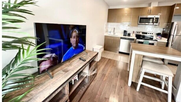 Eine moderne Küche mit Holzschränken, einer Mikrowelle und einem Edelstahl-Kühlschrank.