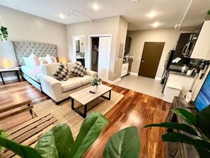 A modern living room with a sofa, coffee table, and large green plant. - 502 Luxury 1BR apartment  in center city
 (Philadelphia)