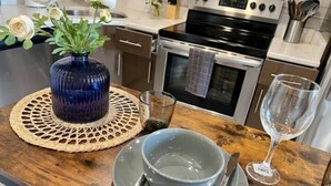 A kitchen with a wooden countertop, a blue vase with flowers, a glass, a bowl, and a wine glass. - 304 Stunning and comfy  1BDR APT in Center city (Philadelphia)
