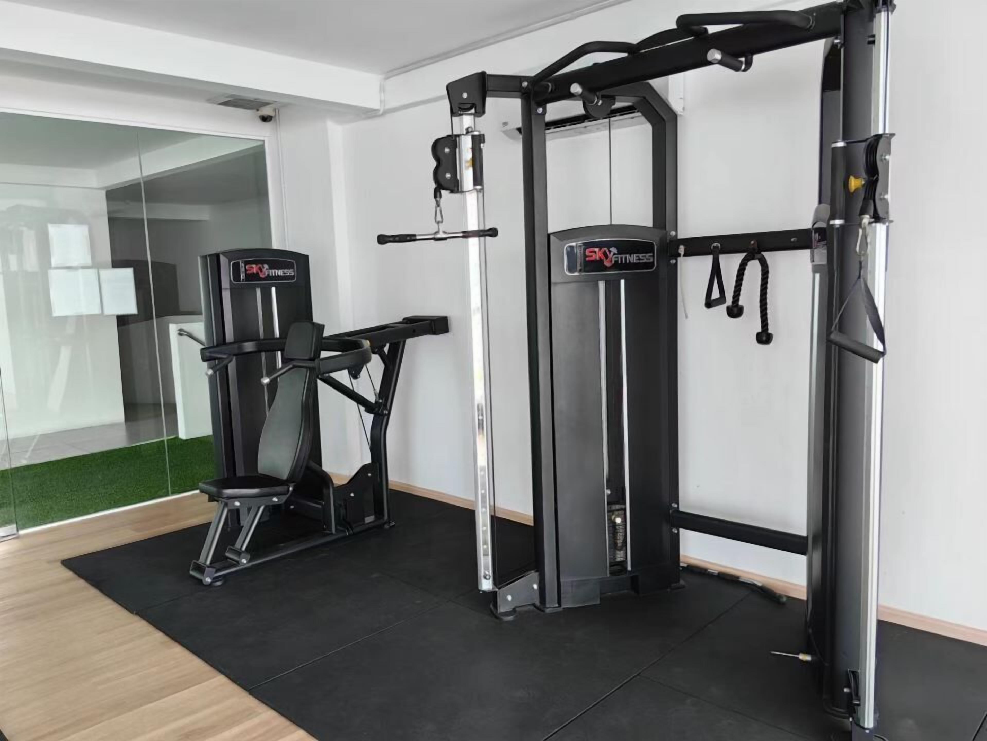 A gym with a treadmill, a chest press machine, and a pull-up bar.