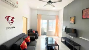 A living room with a sofa set, a coffee table, a TV, and a ceiling fan. - Simfoni Comfy 3BR Suite (Langkawi)
