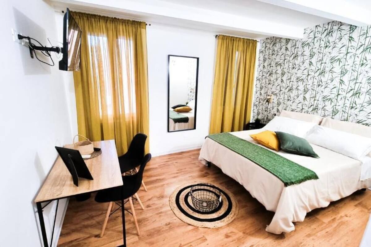 A compact room with a bed, a desk, and a chair.
