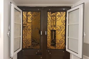 Eine Doppeltür mit aufwendischer Metallverzierung und Glasscheiben.