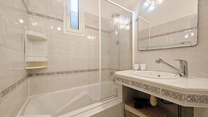 A bathroom with a bathtub, a sink, a mirror, and a shower. - Viva Riviera Quiet Studio Carré d'Or (Cannes)