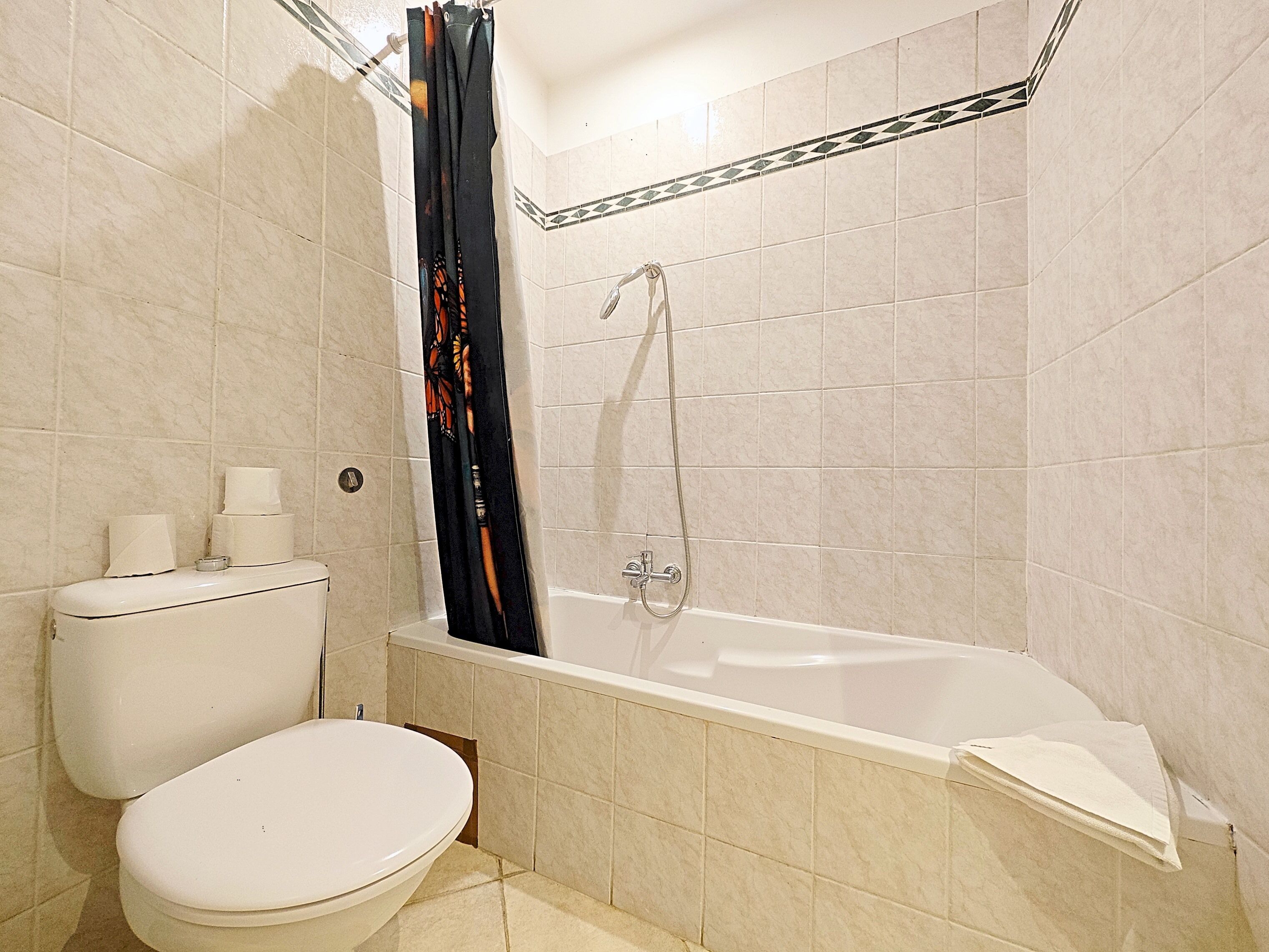 Une salle de bain avec des toilettes, un lavabo et une baignoire.