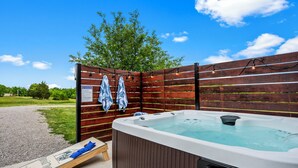 A hot tub with a wooden deck, a wooden fence, and a sign. - Bourbon Trail Near Buffalo Trace-Hot Tub, Fire Pit, BBQ Grill (Frankfort)