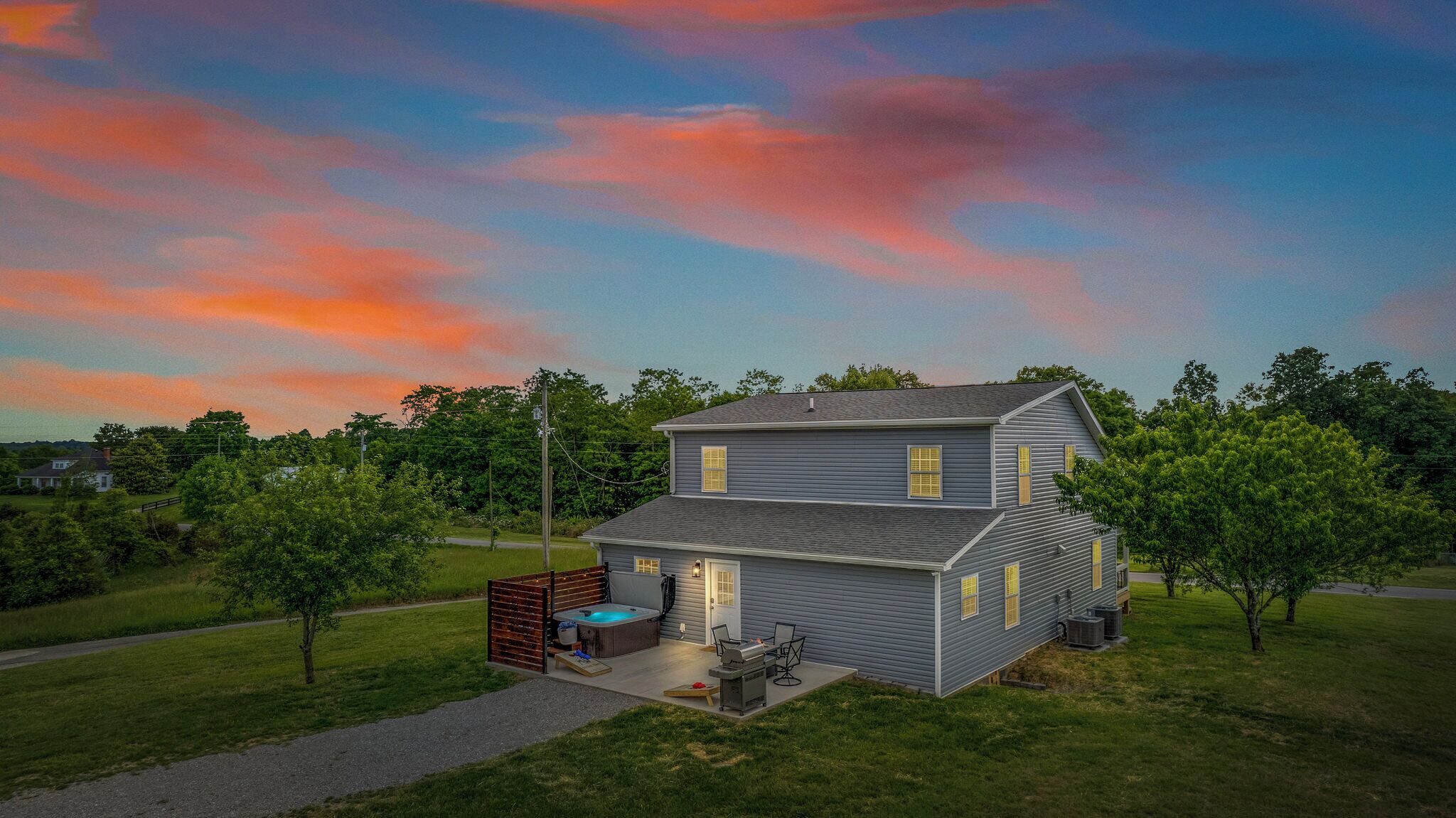 Ein zweigeschossiges Haus mit Terrasse, Whirlpool und Grill.