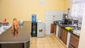 Una cocina equipada con refrigerador, dispensador de agua y cafetera.