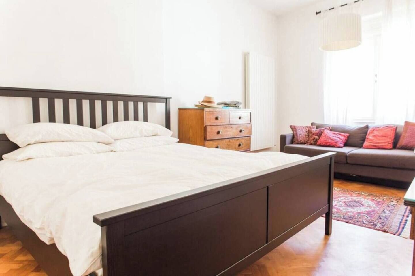 Un dormitorio con cama, cómoda, sofá y ventana.