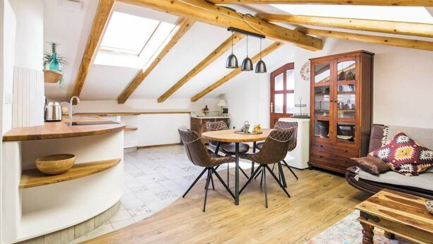 A cozy loft apartment with a dining area, kitchen, and seating space.