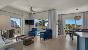 Un vaste salon avec balcon, un coin repas et une cuisine.