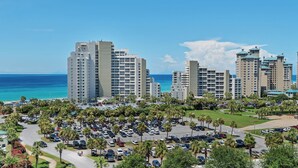 Un complexe hôtelier situé sur la côte, composé de plusieurs immeubles de grande hauteur, d’un parking et offrant une vue sur l’océan.