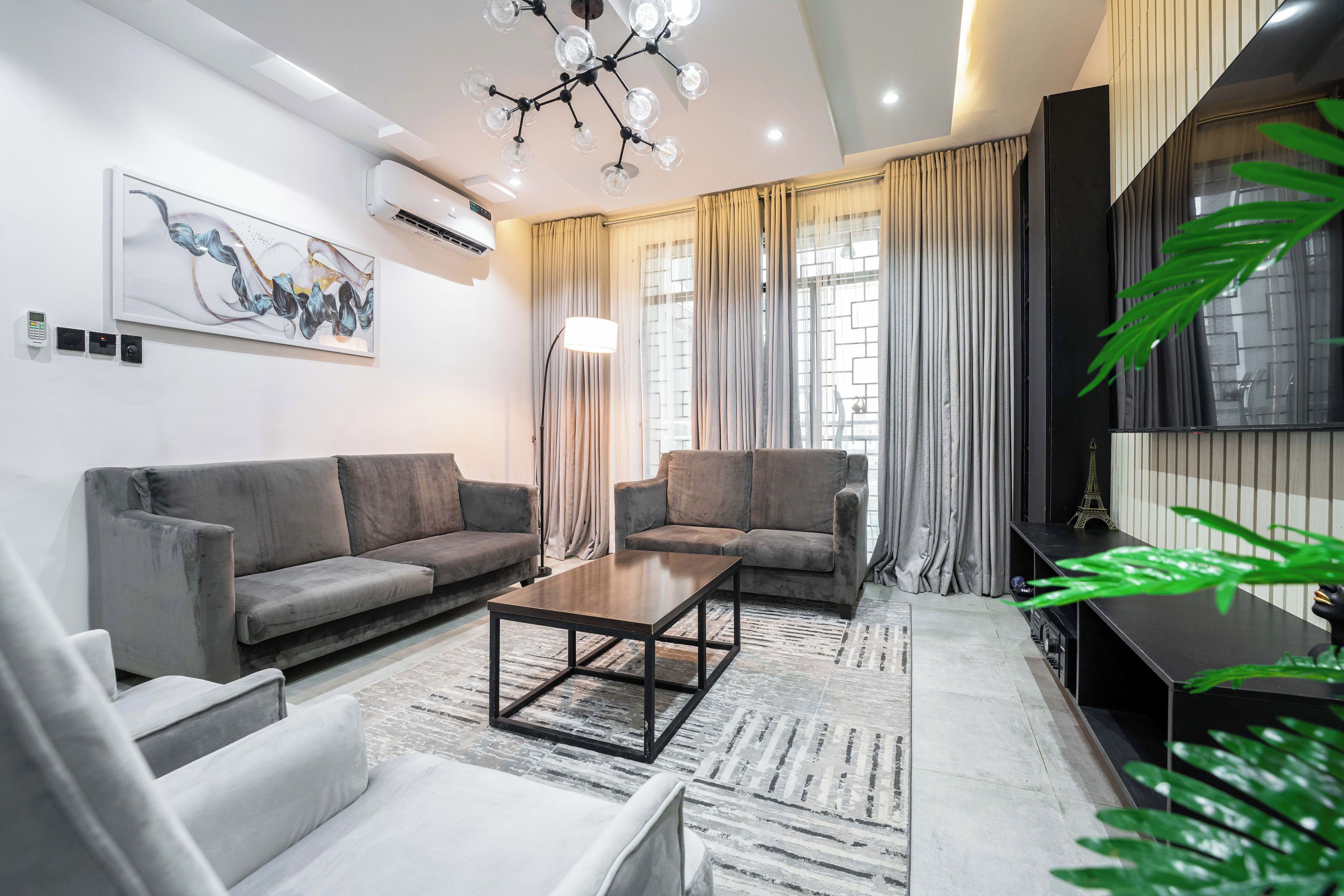 A modern living room with two sofas, a coffee table, and a TV stand.