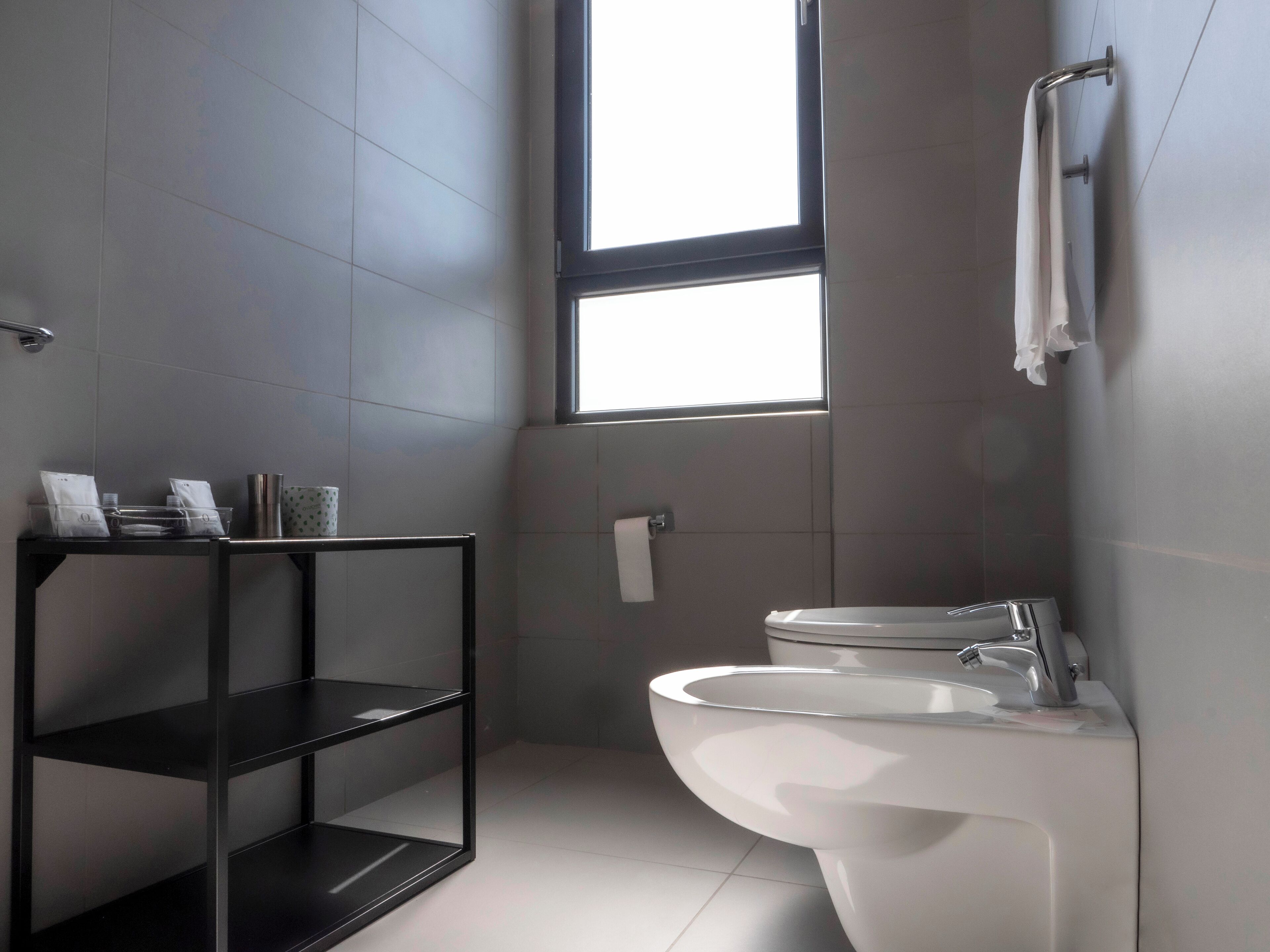 Ein modernes Badezimmer mit Toilette, Waschbecken und einer Ablage.