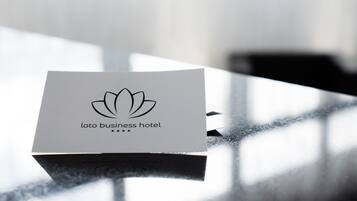 Une carte de visite pour un hôtel d’affaires, avec un logo représentant une fleur de lotus et le texte « Loto business hotel ».