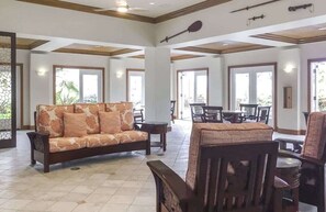 A spacious lobby with a sofa, dining table, and chairs.