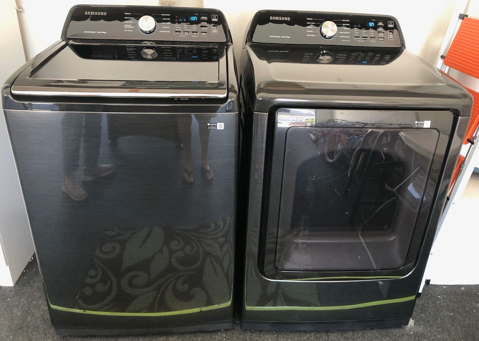 Twee zwarte wasmachines met digitale displays en bedieningspanelen.