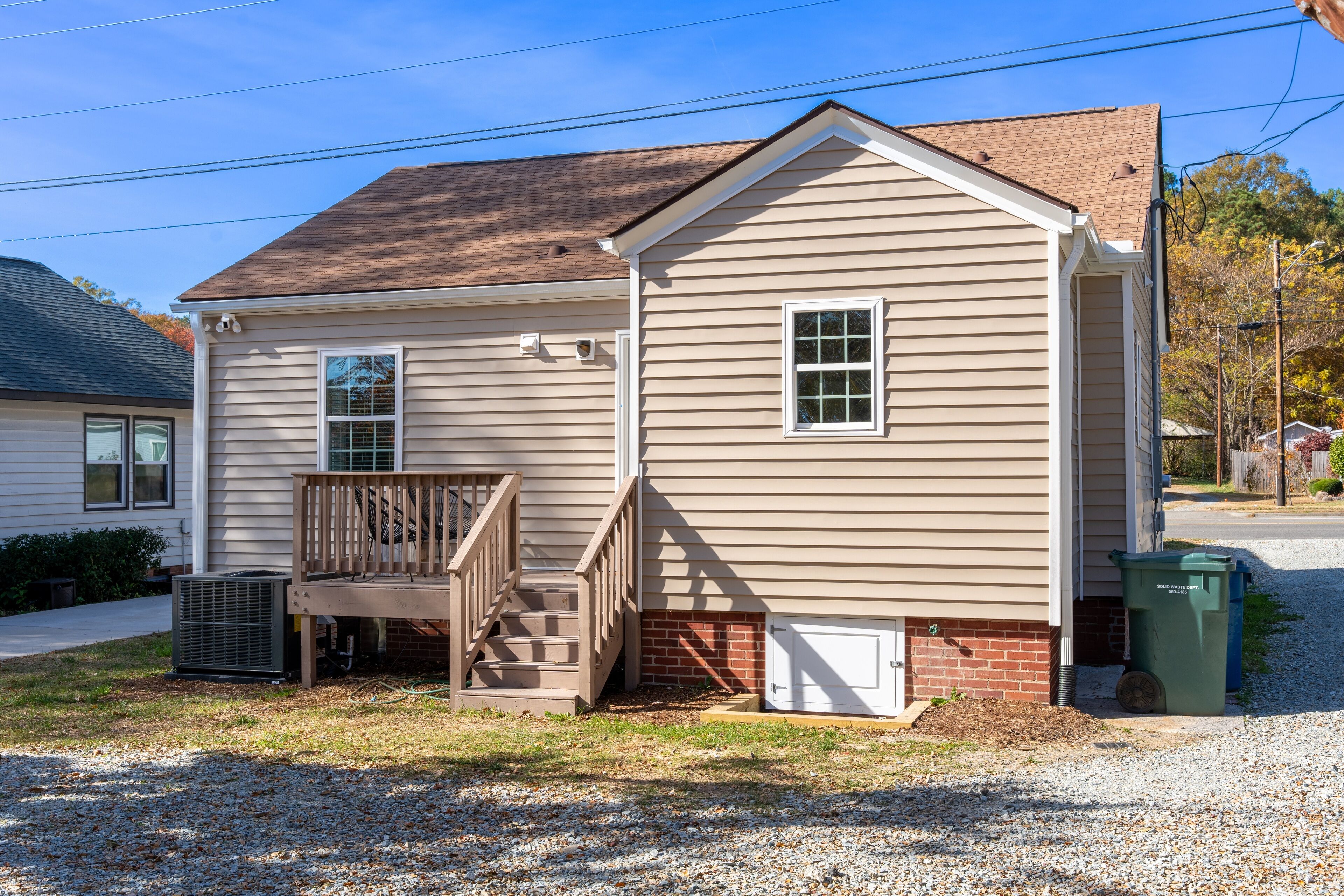 A single-story house with a front porch, a set of stairs leading to the entrance, and a small brick foundation.