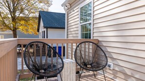 A wooden deck with two black wire chairs and a small table. - 2 BR King Bed Near Duke Hospital & Campus (Durham)