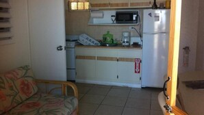 A compact kitchen with a microwave, coffee maker, and a fire safety sign. - Sea View One-Bedroom Apartment in St. Thomas

 (Charlotte Amalie West)