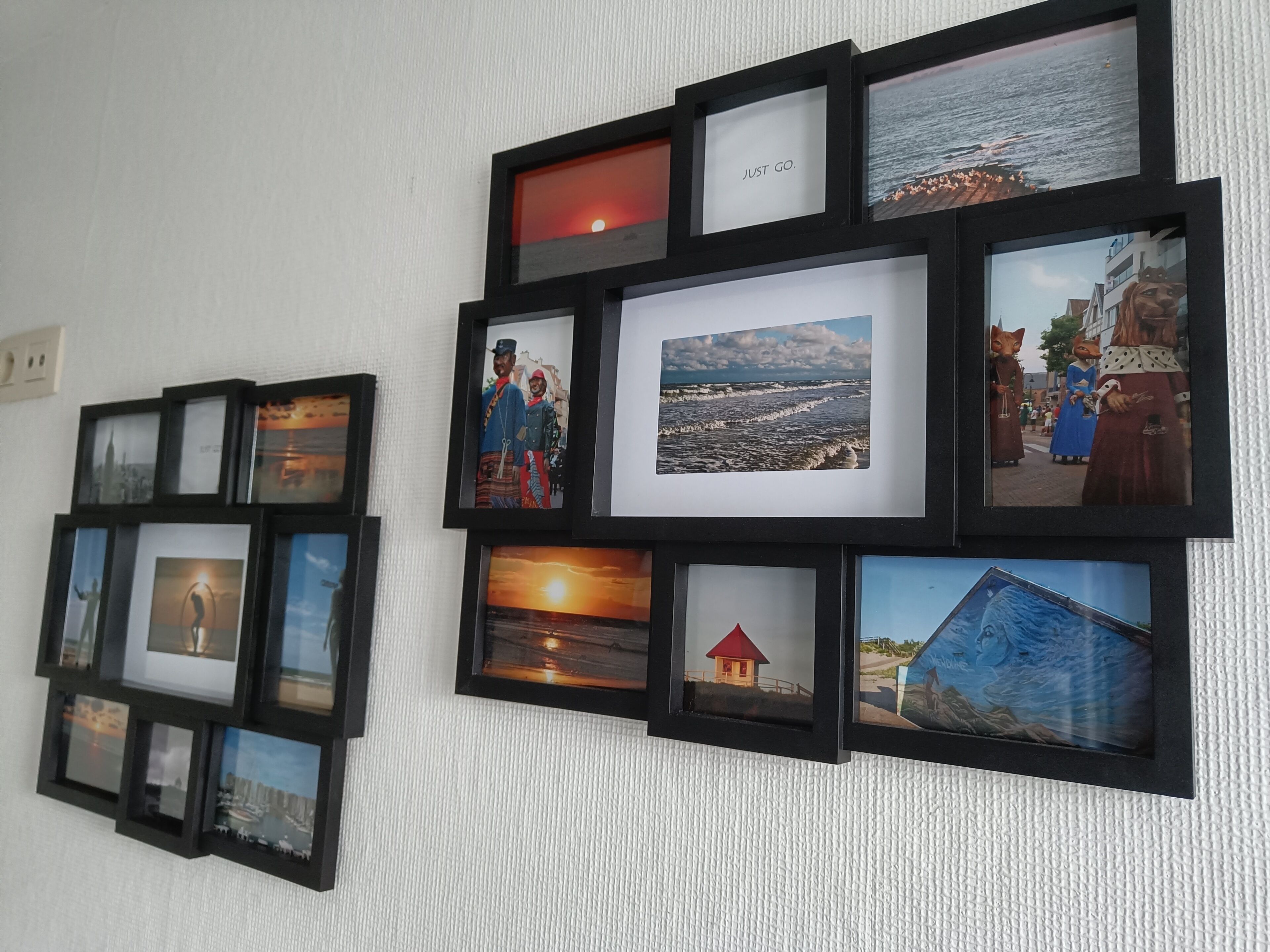 A wall with multiple framed photographs of various scenes, including landscapes, buildings, and animals.