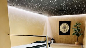 Un jacuzzi en un rincón, con piso de madera y una estatua de Buda.