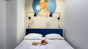 A bedroom with a blue headboard, white bedding, a wall-mounted painting, and a breakfast tray on the bed. - Blue Blood for 11 by Fragola Apartments (Kraków)