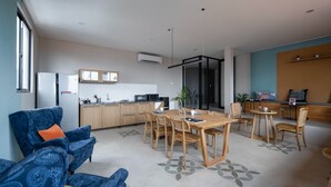 A modern living space with a kitchen, dining area, and seating. - Cove Urbanier (Jakarta)