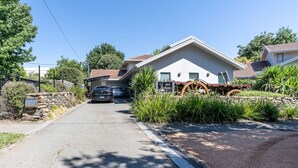 Et toetagers hus med garage, stenvæg og indkørsel.