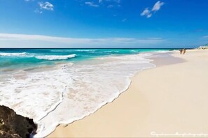 A beach with clear blue water and a sandy shore. - Comfortable, homely condo in paradise Located on the South coast Barbados (Oistins)
