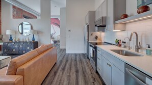 A modern kitchen with grey cabinets, stainless steel appliances, and a white countertop. - The Hive 103 Bees Knees Pet Friendly by BlueStar (Wilmington)