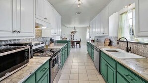 A spacious kitchen with white cabinets, green countertops, and a central island. - Casa Blanca: Hot-Tub & Firepit w/Hill Country View (Fredericksburg)
