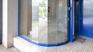 A modern building entrance with a glass door and a sign reading "Sophia. Porto Urban Flat."