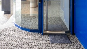 A blue glass door with a sign reading "Sophia. Oporte Urban Flat 100 AL" and a push button.