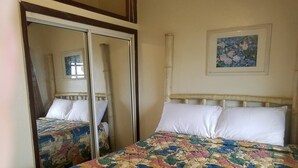 Une chambre à coucher avec un lit, un miroir et un tableau accroché au mur.
