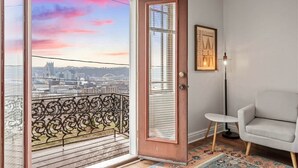A room with a balcony, a door with a window, a chair, and a floor lamp. - Fine View | Rooftop Deck | 4BR (Pittsburgh)