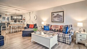 A modern living room with a dining area, a kitchen in the background, and a large framed picture on the wall. - Deerfield Lakefront Condo/Boat Slip Included! (LaFollette)