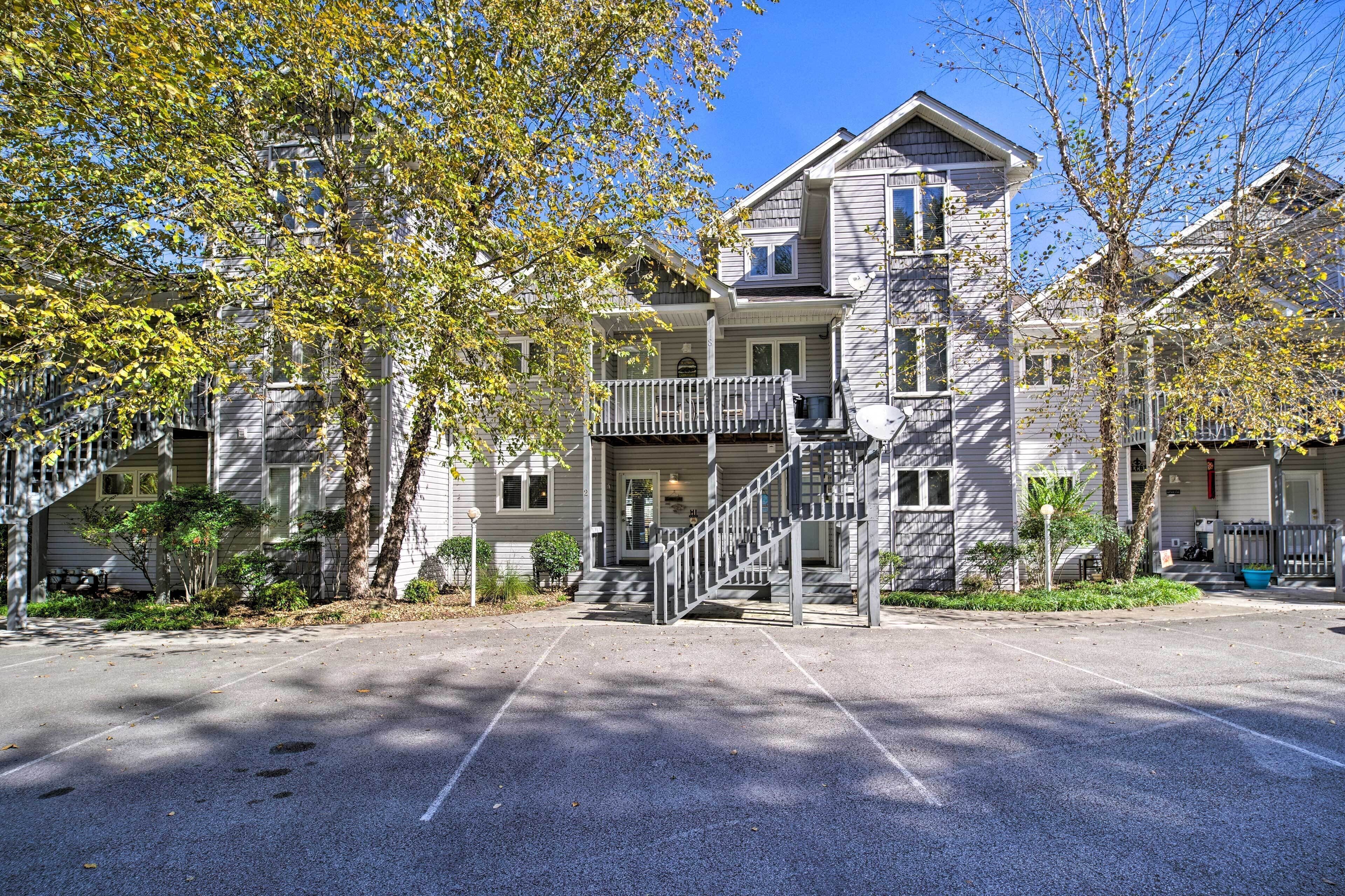 A two-story building with a front porch, a staircase, and a parking lot.