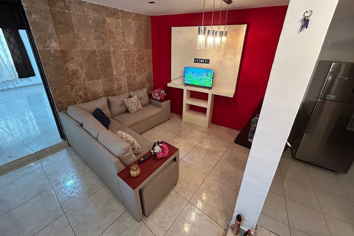 A modern living room with a sofa, a coffee table, and a TV.