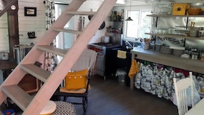 Una cucina con una scala in legno, un lavello e diversi utensili da cucina.