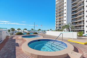A hotel with a pool area, including two circular pools and a rectangular pool, surrounded by a white building with balconies. - Gulf views+ Private beach! Restaurant on site! (Santa Rosa Beach)