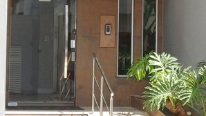 Ein Gebäude mit einem Schild, auf dem „Residencial IRATI“ steht, und einem Glasflurtür-Eingang.