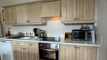 Een magnetron, een oven, kookgerei, borden en bestek