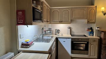 Een magnetron, een oven, kookgerei, borden en bestek