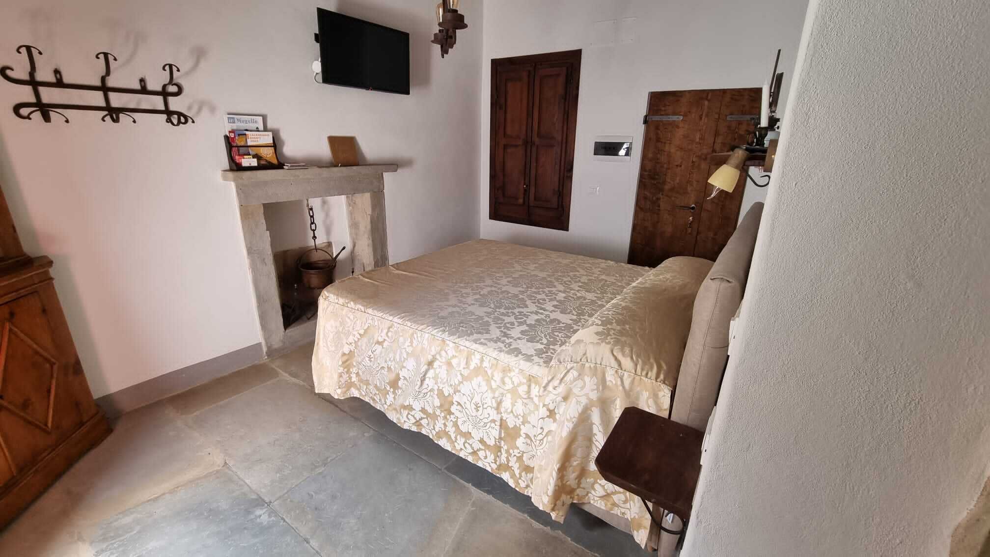 Une chambre à coucher avec un lit, une armoire en bois, une cheminée et une porte en bois.