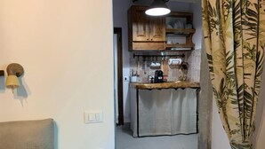 A narrow kitchen with wooden cabinets, a countertop, and a hanging towel.