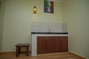 Una cocina con un mueble de madera, una mesa pequeña y un salpicadero de azulejos.