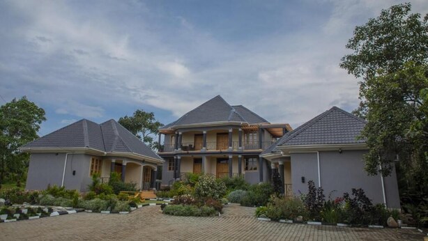 A three-story house with a central balcony and a landscaped garden. - Mt. Rwenzori Golf Resort & Spa (Fort Portal)